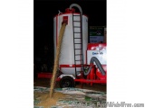 The image shows a large industrial machine with a red and white color scheme. It has a large cylindrical tank with a ladder o...
