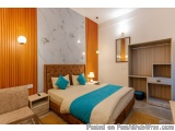 The image shows a modern and luxurious bedroom with a large bed in the center. The bed has a brown tufted headboard and is co...