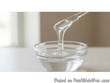 The image shows a small glass bowl with a spoon inside. The spoon is being used to pour a liquid, which appears to be a mixtu...