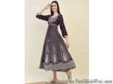 The image shows a young woman wearing a long, flowing dress. The dress is made of a dark purple fabric with a white and black...