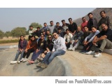 The image shows a group of people posing for a group photo on a concrete surface. There are around 20 people in the photo, al...