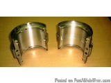 The image shows a pair of metal bearings. They are cylindrical in shape and appear to be made of stainless steel. The bearing...