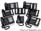 The image shows a collection of nine black landline phones arranged in a scattered manner on a white background. There are ni...