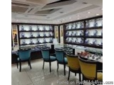 The image shows a large room with multiple rows of shelves on the walls. The shelves are filled with various items such as bo...