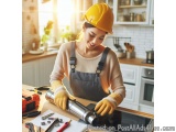 In this image, we can see a young woman wearing a yellow hard hat and overalls, working in a kitchen. She is standing in fron...