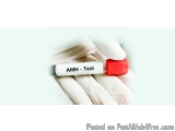 The image shows a hand wearing a white glove holding a test tube with a red cap. The test tube has the words "AMH - Test" wri...