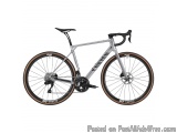 The image is of a silver-colored bicycle with a black seatpost and handlebars. The bike has a sleek and modern design with a...