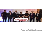 The image shows a group of nine men standing in front of a banner that reads "Corporate Events Planner Near Delhi". The men a...
