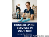 The image shows a young woman wearing a blue apron and blue gloves, cleaning a table with a mop. She is smiling and appears t...