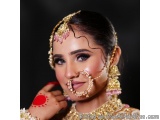The image is a close-up portrait of a beautiful Indian woman wearing traditional Indian jewelry. She is wearing a gold and pi...