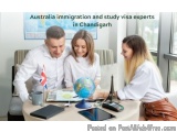 The image shows three people, a man and two women, sitting at a desk in an office. They are all dressed in white and appear t...
