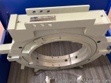 The image shows a white-colored mechanical device, which appears to be a part of a machine or machinery. It has a cylindrical...