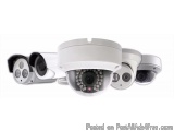 The image shows a set of four security cameras mounted on a white ceiling. The cameras are round in shape and have a white bo...