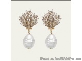 The image shows a pair of earrings. The earrings are made of gold and have a teardrop-shaped pearl in the center. The pearl i...