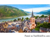 The image is an aerial view of a small town with a river running through it. The town is made up of multiple buildings with c...
