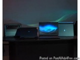 The image shows three laptops on a desk with a dark background. The laptops are arranged in a triangular formation, with the...