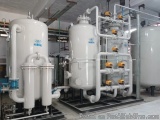 The image shows a large industrial water treatment plant with multiple large tanks and pipes. The tanks are white in color an...