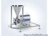 The image shows a Fristam brand industrial machine. It is made of stainless steel and has a cylindrical shape with a funnel o...