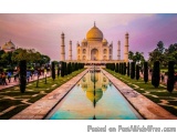 The image is a photograph of the Taj Mahal, a famous monument in Agra, India. The photograph is taken from a low angle, looki...