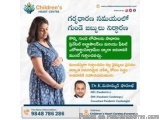 The image is an advertisement for Children's Heart Center in Telugu. It features a pregnant woman wearing a blue dress, stand...