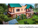 The image shows a beautiful two-story house with a green roof. The house is painted in a combination of orange and yellow col...