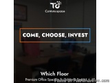The image shows an office space with a desk and chairs in the background. The desk is made of wood and has a computer monitor...