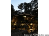 The image shows a small building with a sign that reads "Camp" lit up at night. The building appears to be a restaurant or a...