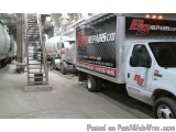 The image shows a large white truck with the logo of BB Repairs Ltd on the side. The truck is parked inside a large warehouse...