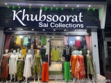 The image shows the entrance of a Khubsoorat Sai Collections store. The store has a large black sign with white text that rea...