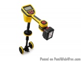 The image shows a yellow and black handheld metal detector with a digital display. The detector has a handle on the top for e...