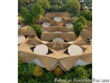 The image is an aerial view of a modern building with a unique architectural design. The building is made up of multiple leve...