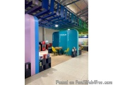 The image shows the interior of a modern store with a colorful and industrial design. The store has a high ceiling with a uni...