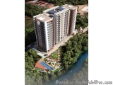 The image is an aerial view of a modern apartment building. The building is tall and has multiple floors with balconies. The...
