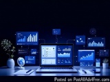 The image shows a desk with a laptop in the center. The laptop screen displays various graphs and charts in blue color. Surro...