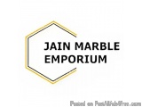 The image is a logo for the Jain Marble Emporium. It is a hexagon-shaped logo with a white background and a gold border. Insi...