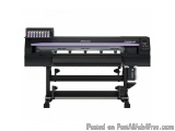 The image shows a large format printer, specifically a Mimaki CVV-1007. It is a large, rectangular machine with a black body...