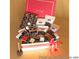The image is of a red and white gift box with the words "Just Truffles" written on the top. The box is open and filled with a...