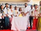 The image shows a group of people standing on a red carpet in front of a banner that reads "St. Mother Teresa School of Nursi...