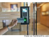 The image shows a person's hand holding a credit card and inserting it into a keypad attached to a glass door. The keypad is...