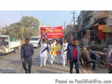 The image shows a group of people walking on a street, holding a banner that reads "Welcome to the Red Cross". The banner is...