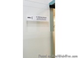The image shows a white door with a label on it. The label reads "OPD1" and "Dr. Krishna Prasad, Consultant, Medical Consulta...