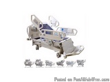 The image shows a medical stretcher, which is a type of stretcher used in hospitals. It is made of metal and has a white fini...