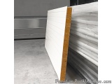 The image shows a stack of white foam insulation panels in a warehouse. The panels are arranged in a horizontal line and appe...