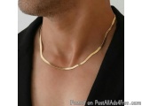 The image shows a close-up of a man's neck and upper chest area. He is wearing a gold necklace that is draped around his neck...