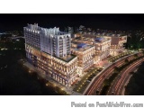 The image is an aerial view of a modern apartment complex at night. The complex is located on a hilltop and is surrounded by...