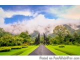 The image is a landscape photograph of a beautiful garden with a long, straight road in the center. The road is surrounded by...
