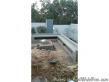 The image shows a construction site with a concrete bench and a concrete structure. The bench is made of concrete and appears...