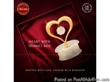 The image is an advertisement for a heart-shaped trinket box. The box is made of red velvet and has a gold-colored lid with a...