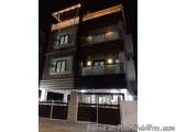 The image shows a modern two-storey building at night. The building is made of brick and has a flat roof. The exterior of the...