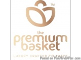 The image is a logo for a company called "The Premium Basket". The logo is a simple design with a white background and a gold...
